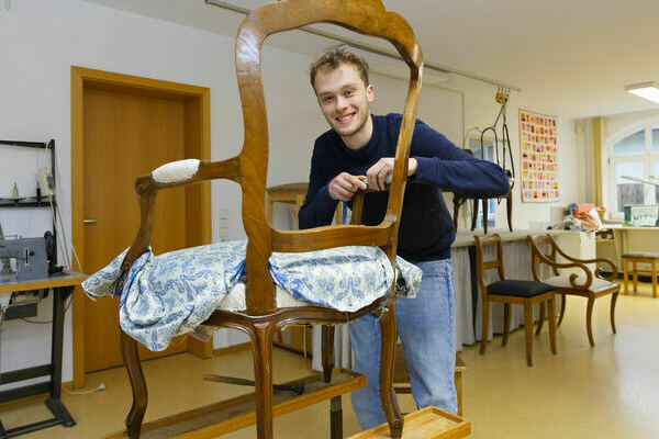 Kilian Strecker beim Polstern eines antiken Sessels